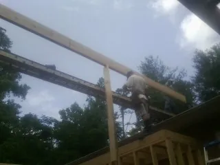 Carpenter setting a ridge beam over a new addition frame — Ice Dam Removal by Roofing Brothers in Sandia Park