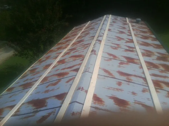 Rusted metal roof panels with new wood purlins before replacement — Storm Damage Roof Repair in Sandia Park by Roofing Brothers