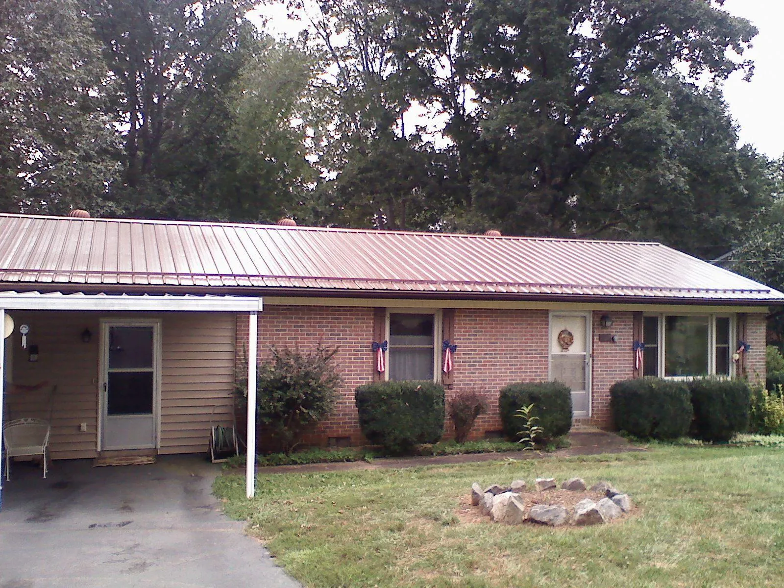 Bronze metal roof and carport on a brick ranch home — Roof Repair work by our crew in Sandia Park