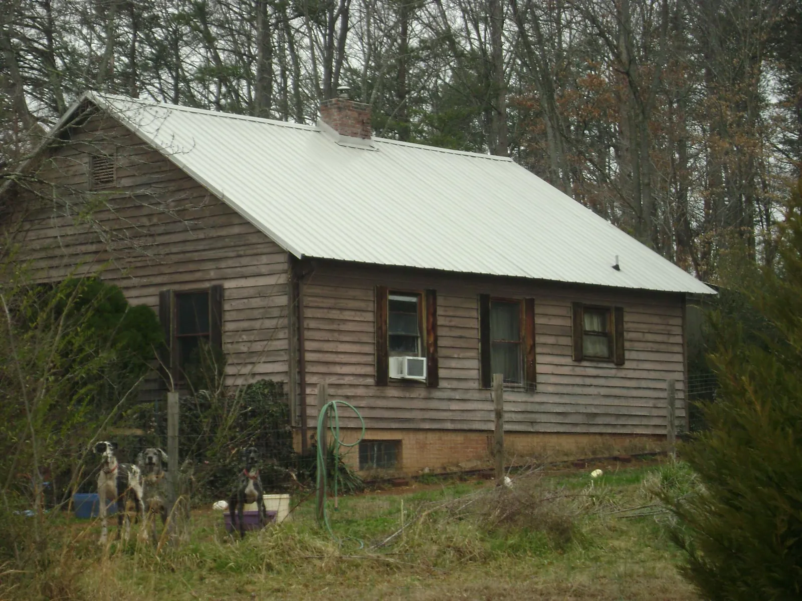 White metal roof on an old wood sided farmhouse, from a Metal Roof Installation job in Sandia Park